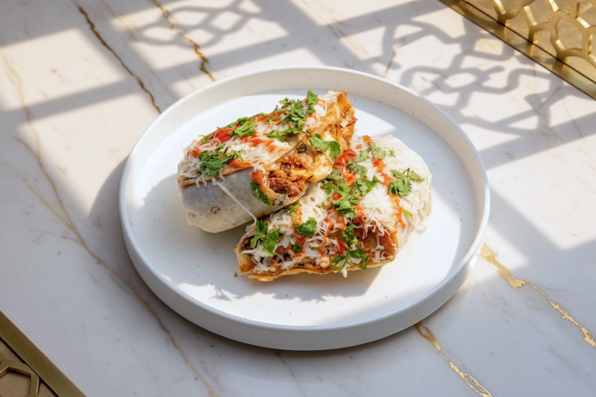 A shawarma roll cut in two on a plate
